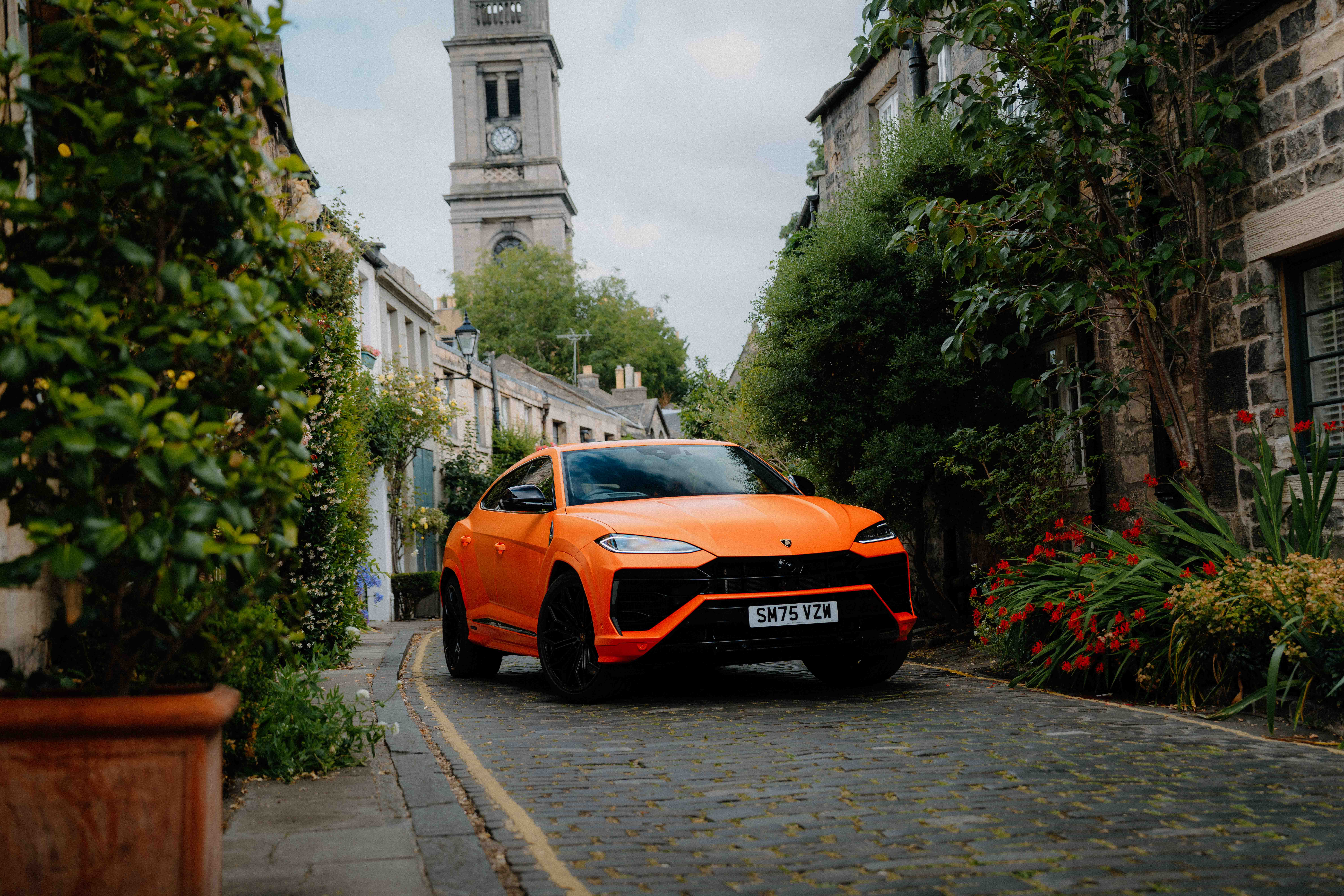 An orange car sitting in a picturesque lane in Edinburgh